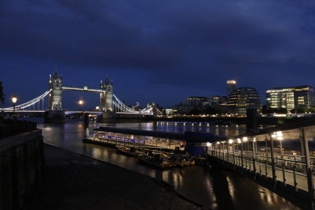 słynny tower bridge wieczorem z błękitnym niebem i odruchem na wodzie - london england thames river sky tower zdjęcia i obrazy z banku zdjęć