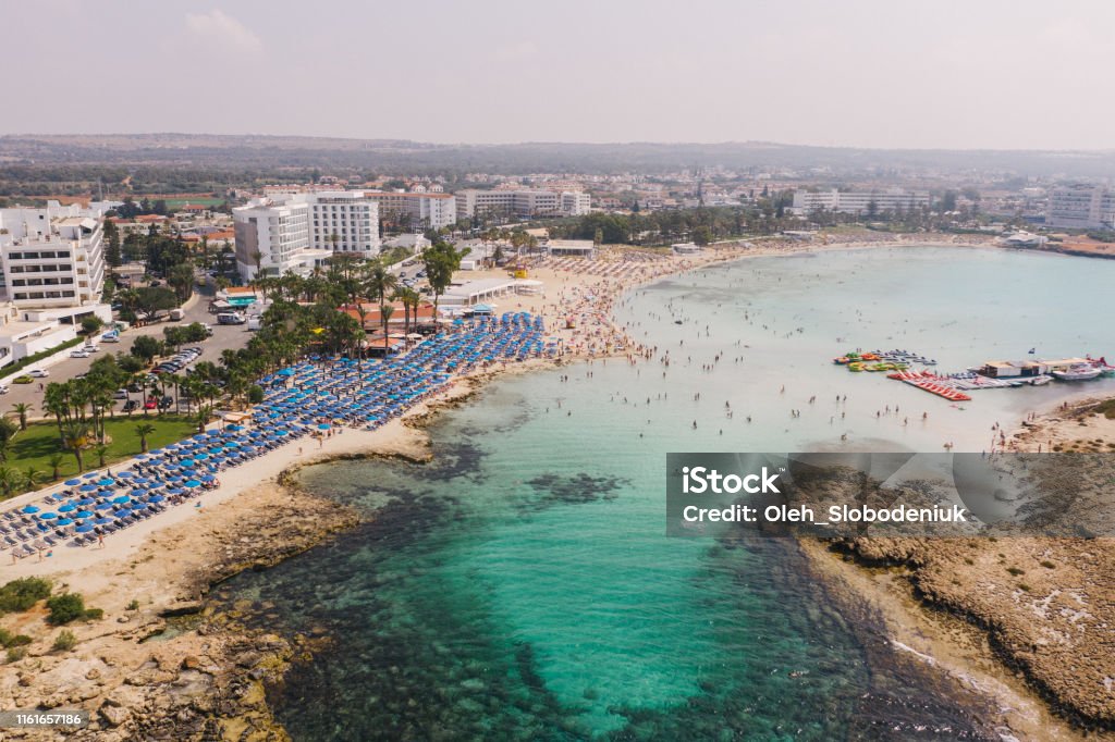 Scenic aerial view of beach with blue umbrellas on Cyprus Scenic aerial view of crowded beach with blue umbrellas on Cyprus Republic Of Cyprus Stock Photo