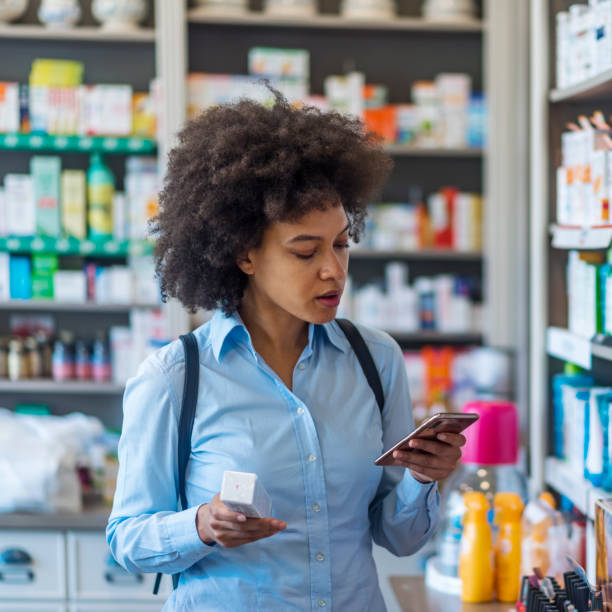 istock Woman uses smart phone while in pharmacy 1161657610