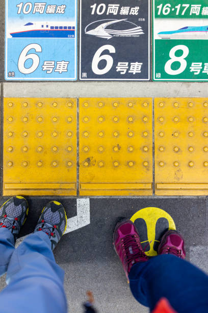 couple, people legs or feet standing on platform with train station car numbers by yellow line - 11262 imagens e fotografias de stock
