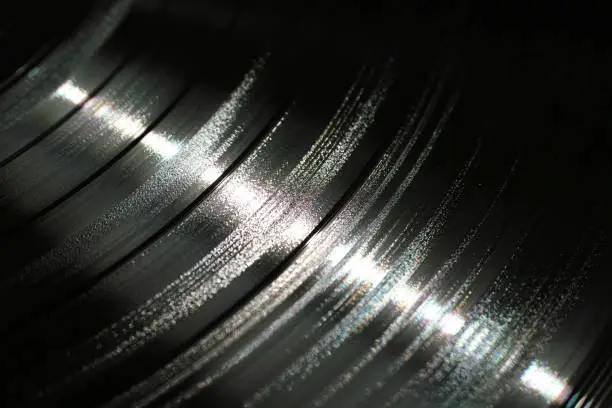 Segment of vinyl record showing the texture of the grooves