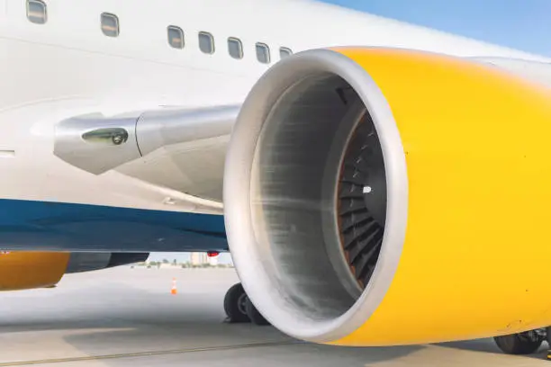 Photo of Close-up big commercial plane engine standing on airfiled after aircraft arrival on bright sunny day