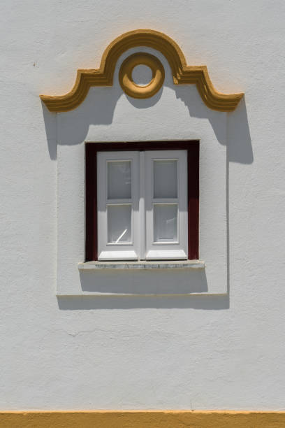 istock European window with classic yellow details on a white wall 1161668092