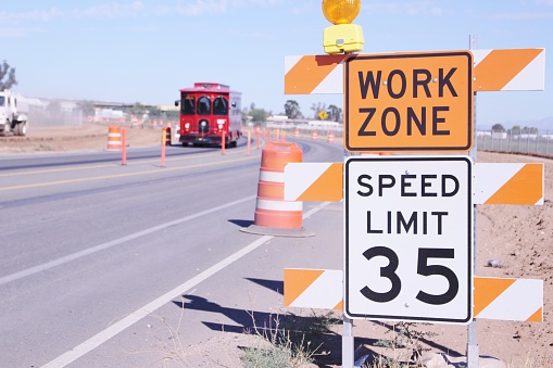 Work Zone sign and Speed Limit Sign on a Roadway Widening Project in Perris California. There is a Trolley in the background.
