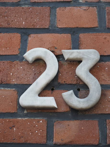 istock House number 23, white numbers on a clinker wall 1161672997