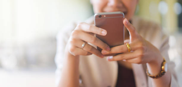 close up young beautiful asian woman looking at smartphone for video online chat with friends or surf the internet or playing mobile application in relax time, millennial technology lifestyle concept cerrar joven hermosa mujer asiática mirando el teléfono inteligente para el chat en línea de vídeo con amigos o navegar por internet o jugar aplicación móvil en el momento de relajarse, concepto de estilo de vida de la tecnología milenaria