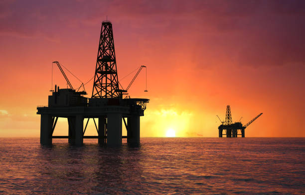 Silhouette oil rig Oil rig silhouette over orange sky drilling rig stock pictures, royalty-free photos & images