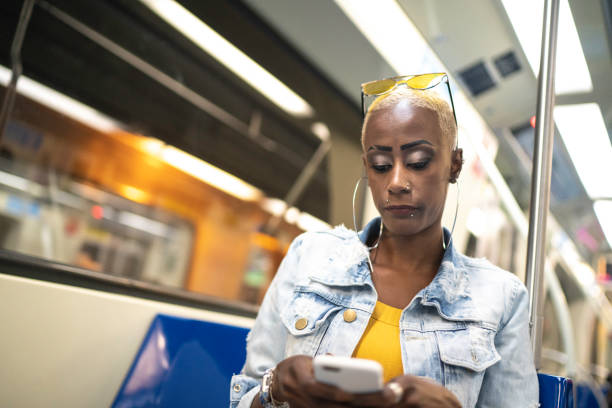 istock Woman sitting in subway train and using cellphone 1161680542