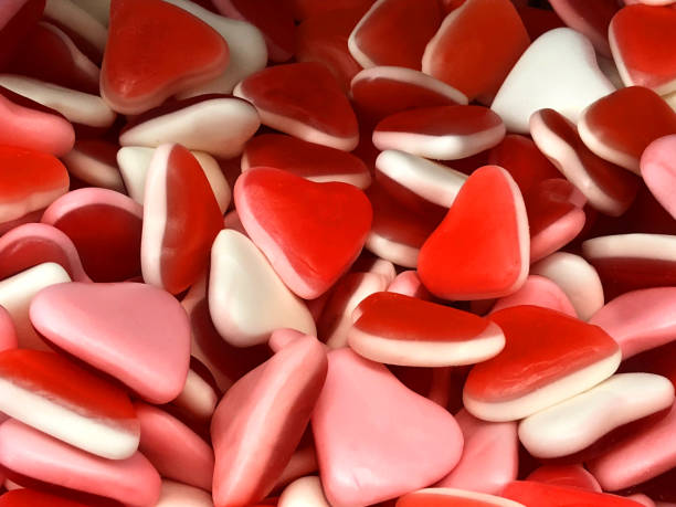 image of sweets confectionary of jelly bean love heart candy for sale in traditional english sweet shop, soft red, white, pink jelly sweets wallpaper background for children's treat / unhealthy eating diet, romantic valentine's day gift to say i love you - valentines day candy chocolate candy heart shape imagens e fotografias de stock