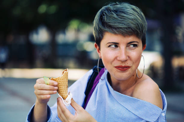 istock Beautiful woman eating ice-cream 1161683803