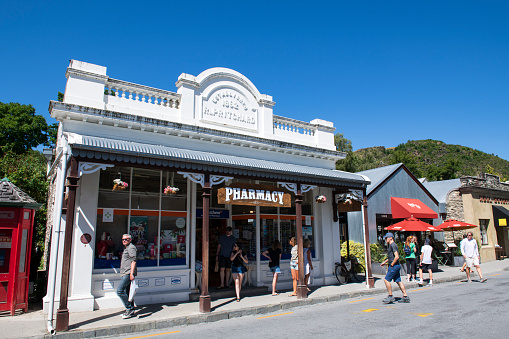 Arrowtown, New Zealand - December 25, 2018. Historic pharmacy store with people walking on street in Arrowtown, a historic gold mining town on South Island, New Zealand