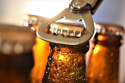 beer bottle opening against sun set