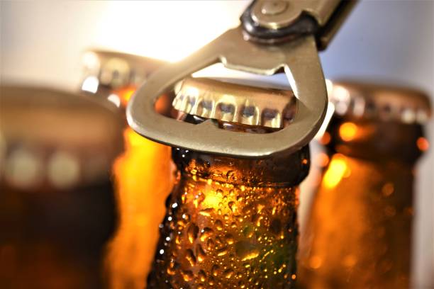 beer bottle opening beer bottle opening against sun set beer bottle photos stock pictures, royalty-free photos & images
