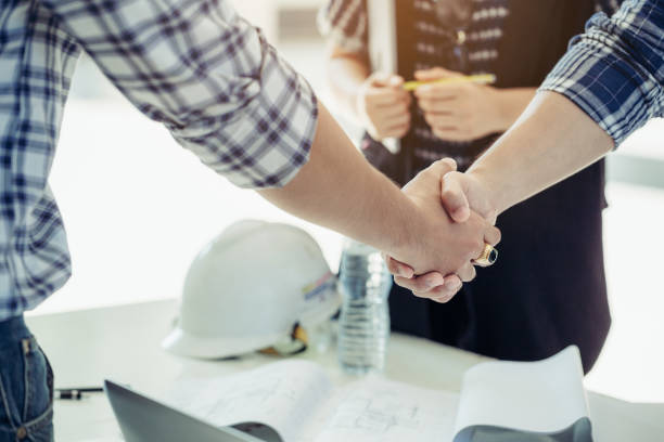 Engineers shake hands together with the secretary girl at the side. stock photo