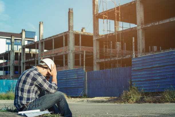 A young engineer is sitting stressed. Because the construction project was canceled. stock photo