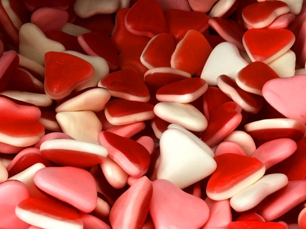 image of sweets confectionary of jelly bean love heart candy for sale in traditional english sweet shop, soft red, white, pink jelly sweets wallpaper background for children's treat / unhealthy eating diet, romantic valentine's day gift to say i love you - valentines day candy chocolate candy heart shape imagens e fotografias de stock
