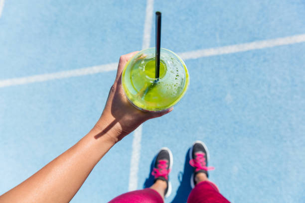 istock Runner drinking a green smoothie on running track 1161701235