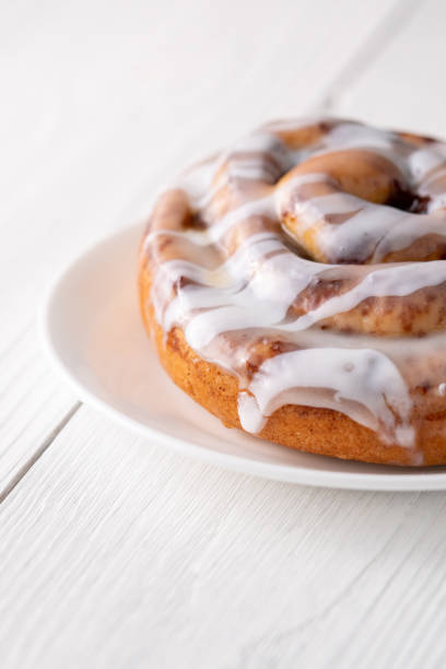istock Large gourmet frosted cinnamon roll on white farmhouse table 1161701237
