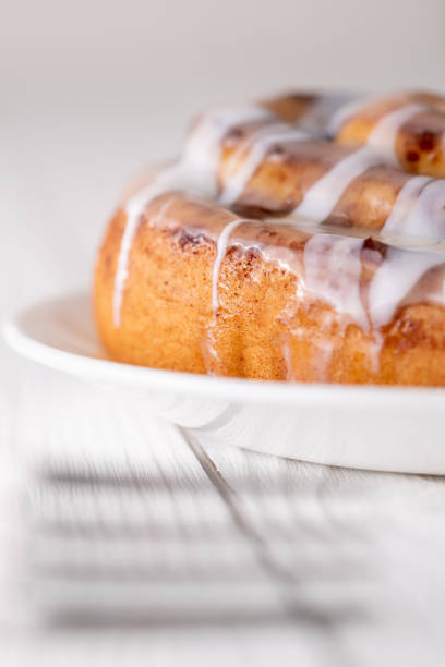 istock Large gourmet frosted cinnamon roll on white farmhouse table 1161701251