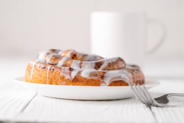 istock Large gourmet frosted cinnamon roll on white farmhouse table 1161702300