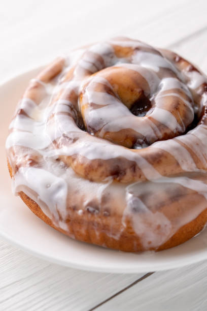 istock Large gourmet frosted cinnamon roll on white farmhouse table 1161702325