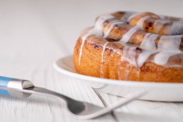 istock Large gourmet frosted cinnamon roll on white farmhouse table 1161702349
