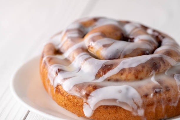 istock Large gourmet frosted cinnamon roll on white farmhouse table 1161708836