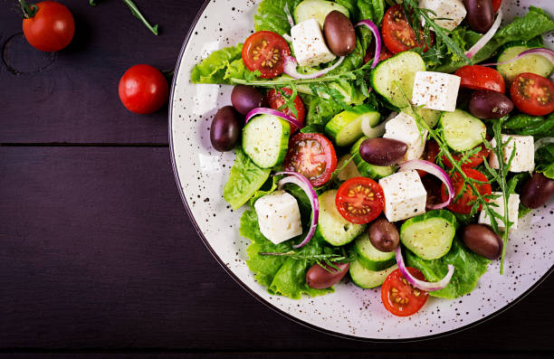 Greek salad with fresh vegetables, feta cheese and kalamata olives. Healthy food. Top view stock photo