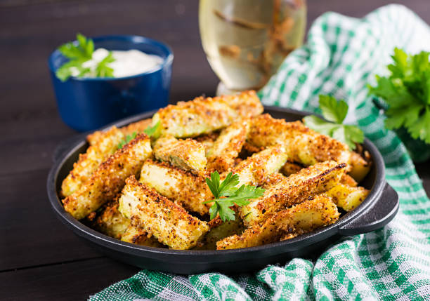Baked zucchini sticks with cheese and bread crumbs. Vegan food. Vegetarian cuisine. stock photo