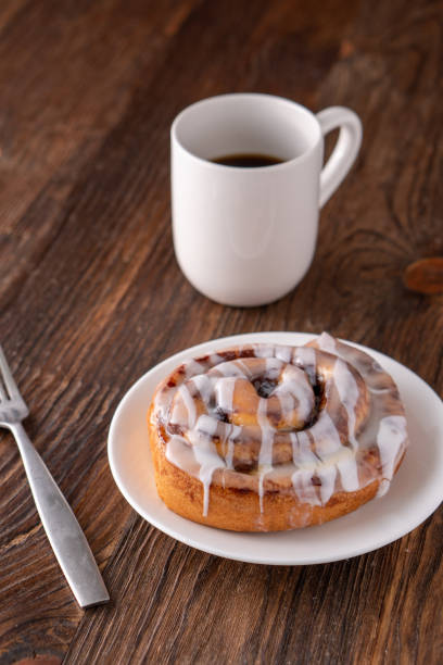 istock Large gourmet frosted cinnamon roll on brown distressed table 1161712949