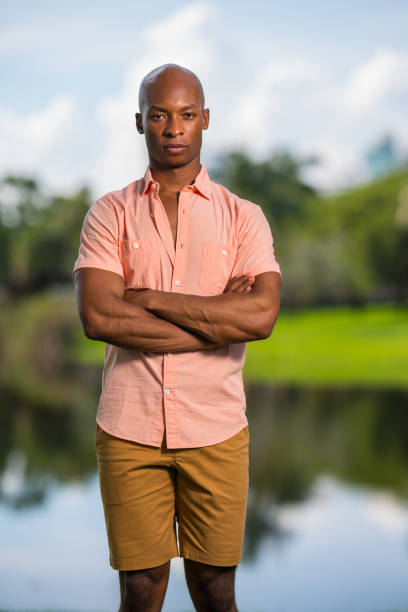 istock Man posing in a pink button shirt with arms crossed 1161713149