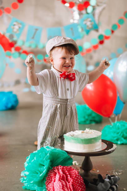 istock Baby boy touching his first birthday cake. Making messy cakesmash in decorated studio location 1161713309