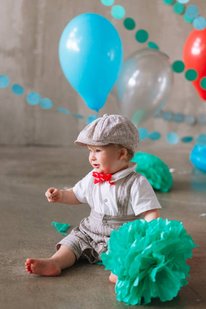 istock year-old boy in suit standing in decorated studio room looking up. Full-lenght vertical portrait 1161713403
