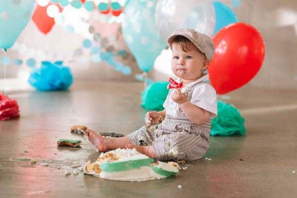 istock Baby boy touching his first birthday cake. Making messy cakesmash in decorated studio location. Dirty bare foot 1161713429