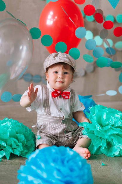 istock year-old boy in suit standing in decorated studio room looking up. Full-lenght vertical portrait 1161713820