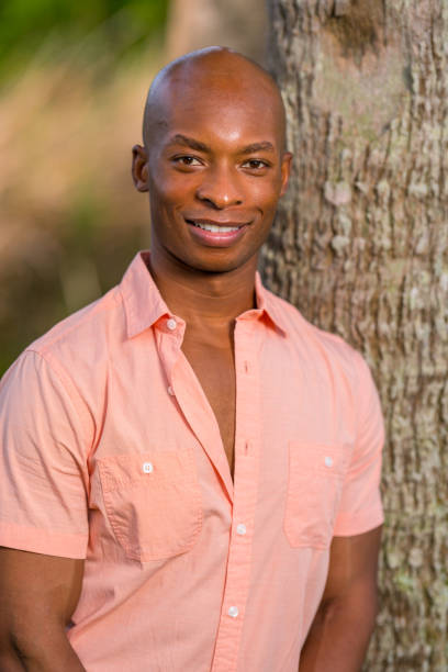 istock Handsome young black man posing by a tree in the park 1161714126