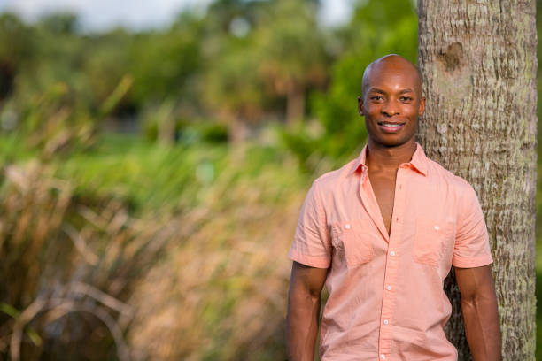 schöne afroamerikanische männliche modell posiert in einem rosa knopf shirt - offener kragen stock-fotos und bilder