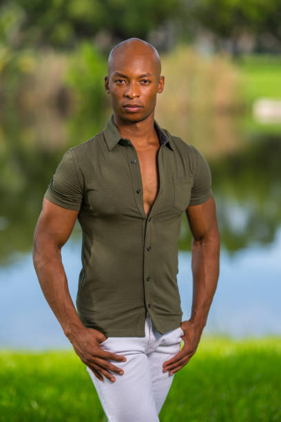 istock Photo of a handsome man posing with hands in pockets at a park setting 1161716092