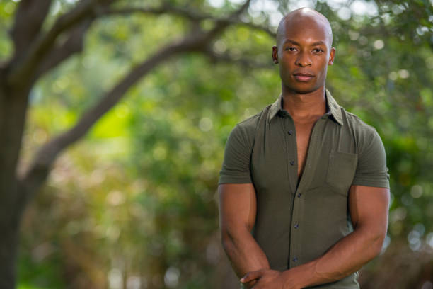 istock Handsome black model posing outdoors in a nature scene blurry trees with background bokeh 1161716384