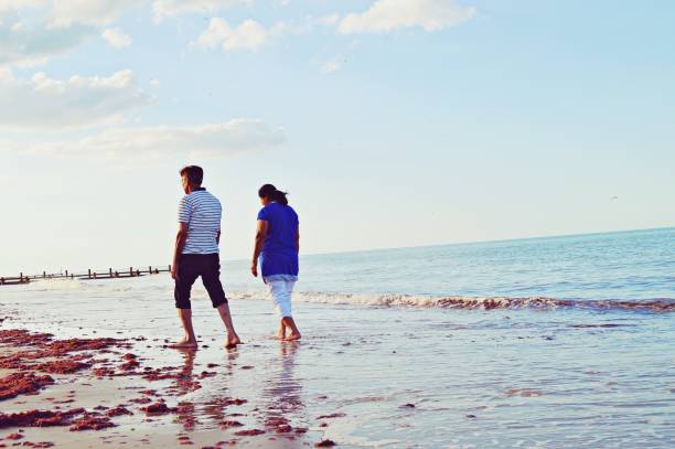 istock An elderly couple taking a walk by the sea on a sandy beach 1161718330