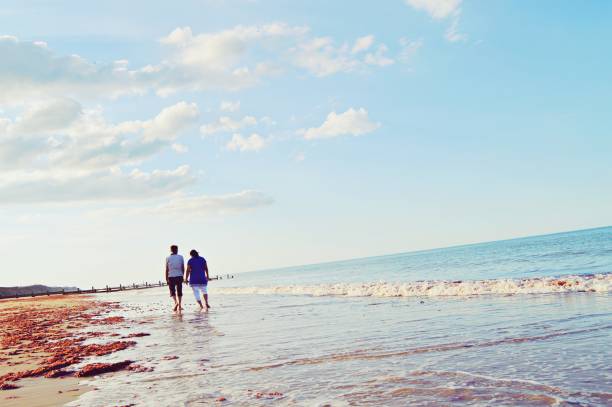 istock An elderly couple taking a walk by the sea on a sandy beach 1161718399
