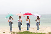 雨の沖縄ビーチで若い4人の女性
