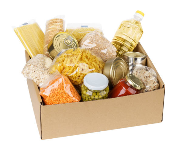 Open cardboard box with oil, canned food, cereals and pasta. Donation box with various food. Open cardboard box with oil, canned food, cereals and pasta. Isolated. food staple stock pictures, royalty-free photos & images
