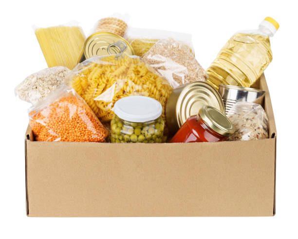 varios alimentos enlatados, pasta y cereales en una caja de cartón. - alimento conservado fotos fotografías e imágenes de stock