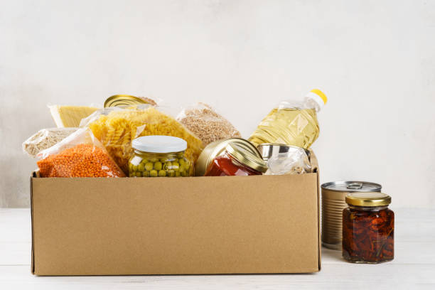varios alimentos enlatados, pasta y cereales en una caja de cartón. - oatmeal oat box container fotografías e imágenes de stock