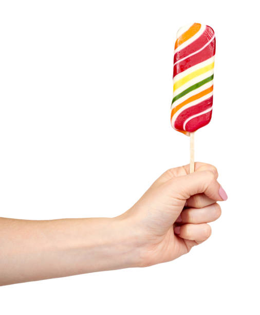 istock Hand with striped color lollipop, bright cool candy. 1161723285