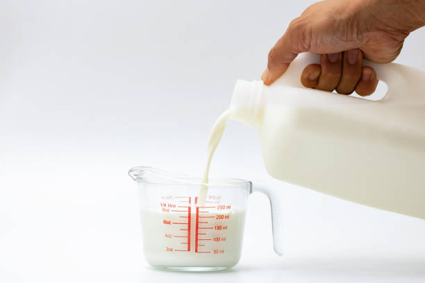 istock pour milk in glass measuring cup on white background 1161724005