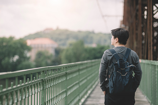An Asian Chinese female looking at scenery in Prague railways bridge