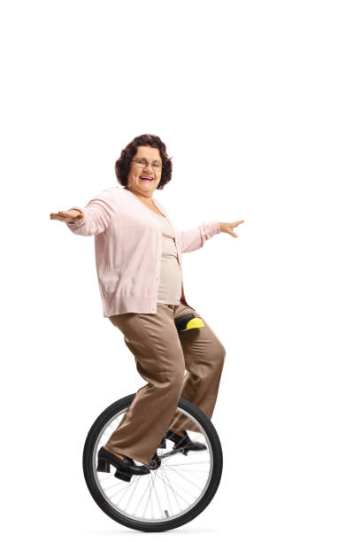 istock Senior woman riding a unicycle and smiling 1161728130