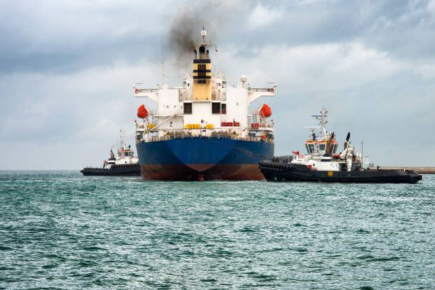 istock Tugboat moving cargo ship in the harbor 1161731129
